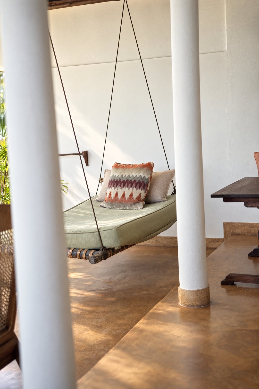 House hanging daybed between the veranda columns