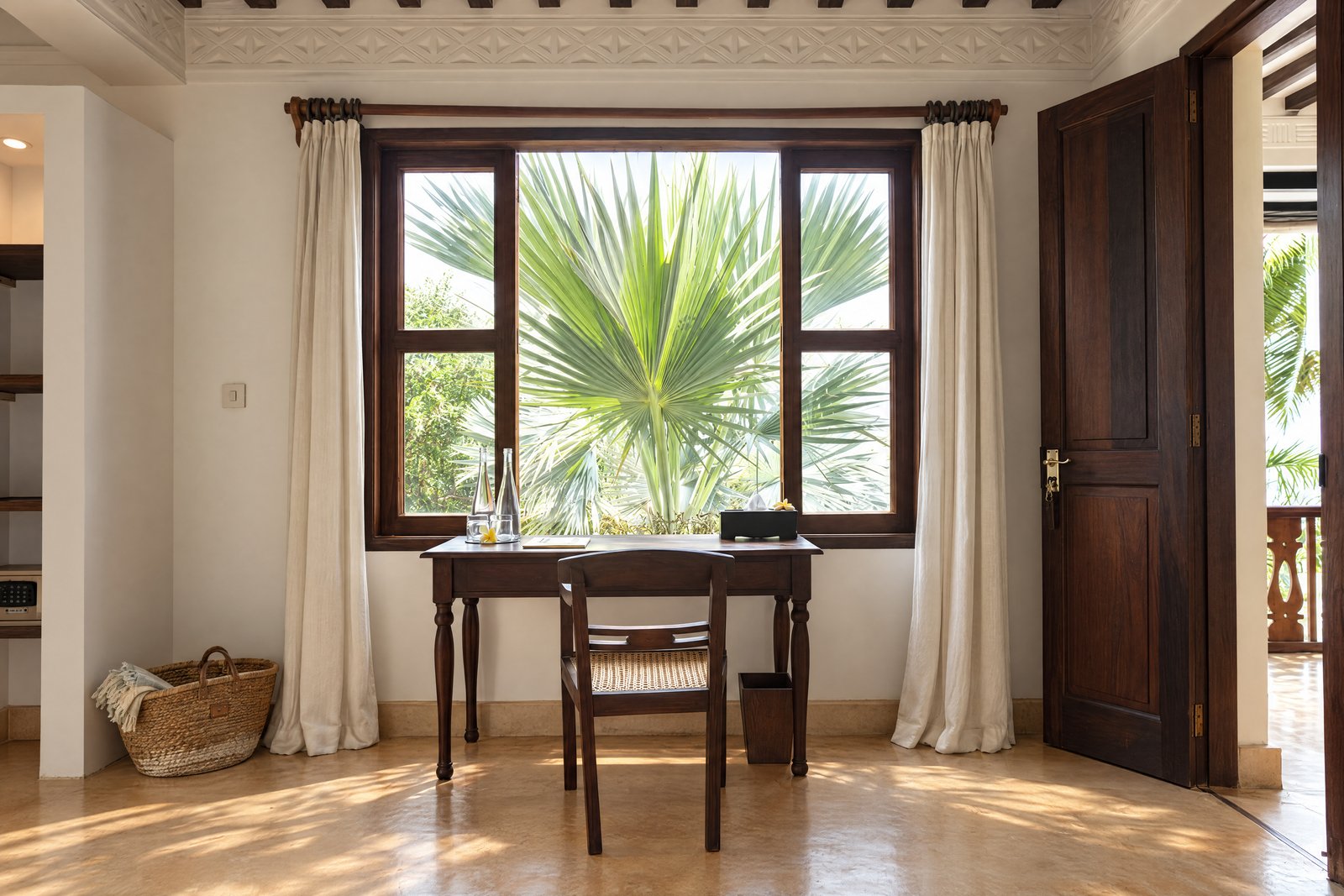 Writing desk framed by a fan palm