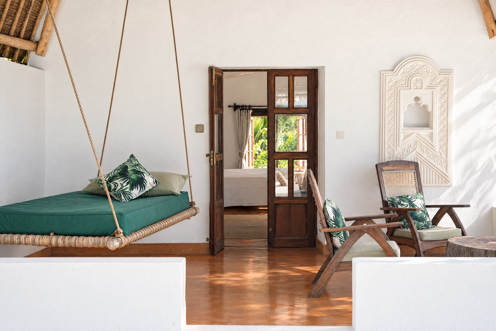 Green hanging daybed and carved-niche veranda